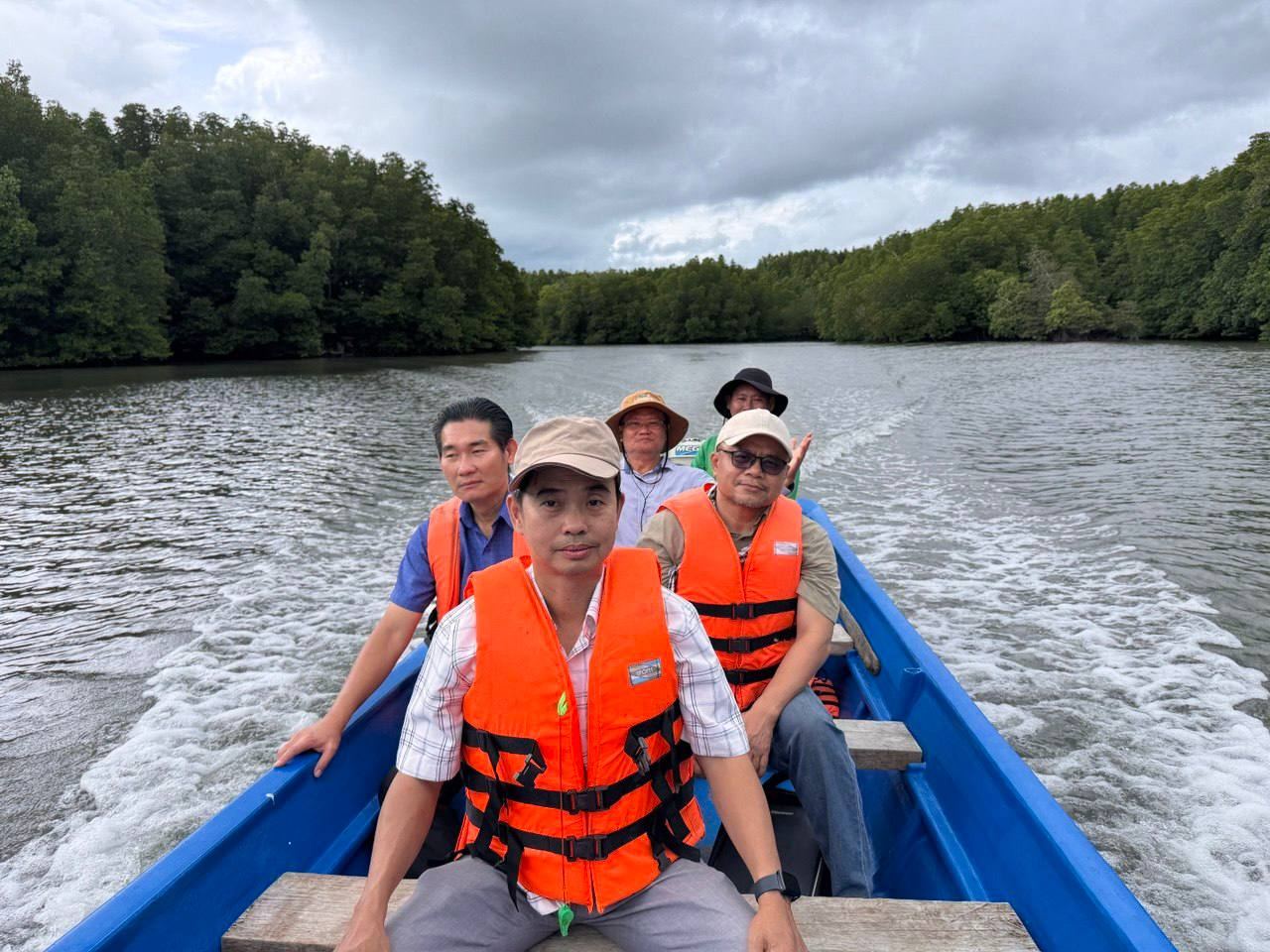 Bright Life field team in life jackets travelling by boat along a mangrove-lined river in Koh Kong